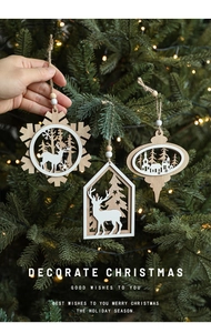 Detail of wooden Christmas ornaments with reindeer and snowflakes on a lighted tree