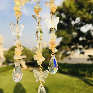 Detail of crystal suncatcher with yellow stones and iridescent rainbow pendant