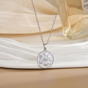 Silver chain necklace with a round white pendant featuring moon and elephant symbols