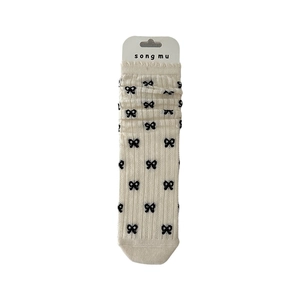 Ballet style cream ribbed socks with black bow patterns and branded hangtag detail