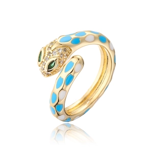 Detail of snake ring featuring blue enamel patterns and green gemstone eyes on 18k gold