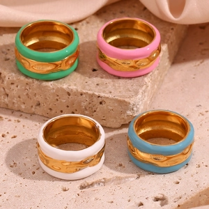 Close-up of four 18K gold plated water ripple rings with colorful enamel drip oil finish