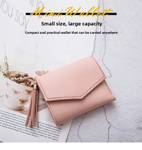 Dettaglio mini portafoglio rosa in pelle PU con trama a grana e nappa decorativa