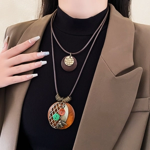 Détail d'un collier double couche rétro avec pendentif en bois et oiseau en métal