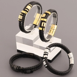 Close-up of multilayer braided leather bracelets with gold, silver and black metal clasps