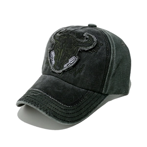 Detail of vintage grey washed baseball cap featuring bull head embroidery and frayed brim