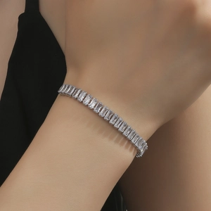 Macro shot of a sparkling silver bracelet with baguette-cut zircons on a model's wrist
