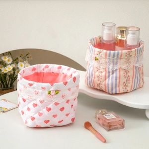 Quilted fabric storage baskets with floral heart patterns and delicate lace trim
