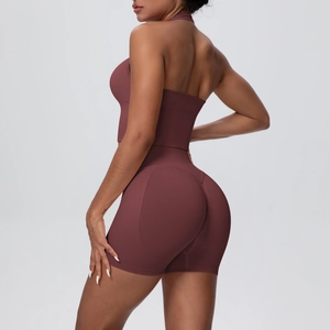 Detail of high-waisted seamless yoga shorts and halter sports bra in reddish brown