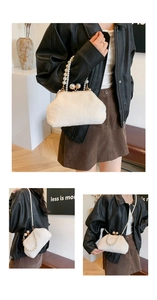Detailed view of white faux fur bag with pearl handle and golden clasp on a model