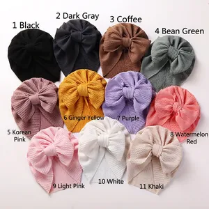 Detail showing various colors of ribbed knit baby turbans with large bows for toddlers