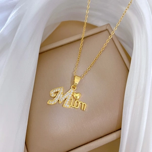 Elegant gold-tone Mama heart necklace with rhinestones on a minimalist jewelry display