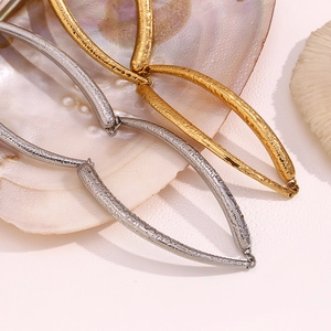 Close-up of gold and silver necklaces featuring unique hammered textures and a bamboo design