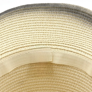 Dettaglio di cappello di paglia western con etichetta 100% carta e fascia tergisudore
