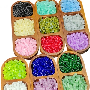 Bamboo shaped glass tube beads in various colors for DIY jewelry making in wooden tray