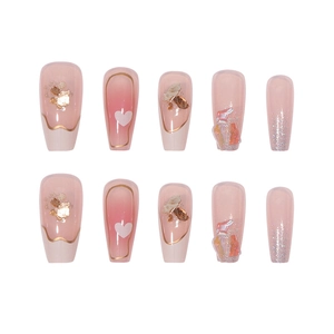 Pink gradient press-on nails with gold leaf heart accents and glitter diamonds
