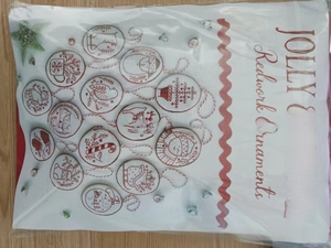 Packaged set of handmade redwork embroidered Christmas tree ornaments with festive motifs