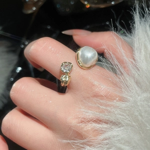 Detail of vintage gold open ring with round white pearl and sparkling zircon stone