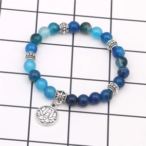 Dettaglio del bracciale con perline blu, ciondolo a loto d'argento e distanziatori vintage