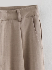 Detail of khaki twill straight pants showing high waist cut and side pocket texture