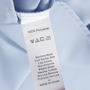 Macro detail of washing label showing 100% polyester fabric and care instructions