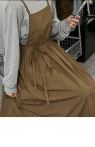 Détail du tablier plissé marron avec lien de taille ajustable sur un mannequin