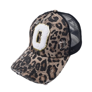 Detailed macro view of vintage leopard print mesh baseball cap with embroidered letter patch