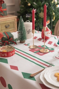 Close-up of Christmas tablecloth with red and green geometric patterns and festive tassel edge