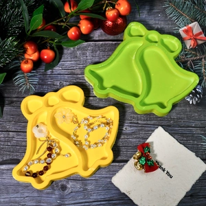 Detail von glockenförmigen Silikonformen in Gelb und Grün für Weihnachts-Harz-Tabletts