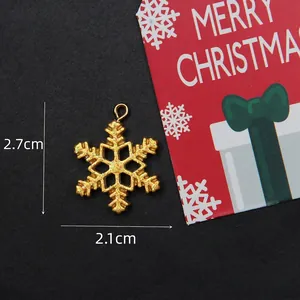 Detailed view of a gold glitter snowflake charm with hanging loop for DIY jewelry