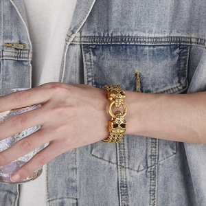 Macro shot of men's gothic gold skull bracelet with thick woven link chain texture