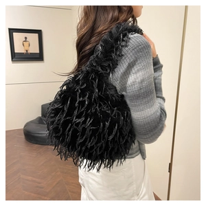 Detail of the black plush tassel shoulder bag showing the fuzzy texture and fringe design