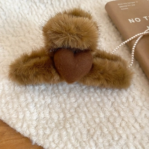 Detailed view of a brown plush heart hair claw clip with faux fur and metal spring