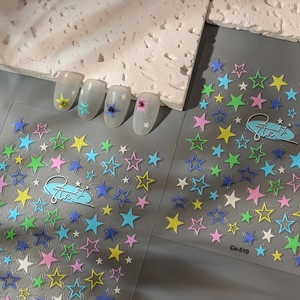 Detailed view of colorful star nail art stickers and rhinestone manicured samples