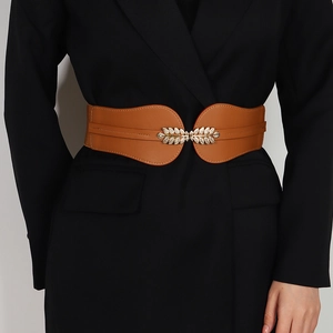 Brown elastic waist belt featuring a gold leaf buckle with rhinestones on a blazer