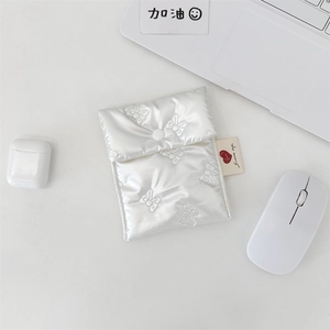 Macro shot of white quilted mini storage pouch with 3D embossed butterfly pattern