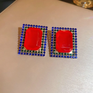 Detailed macro of vintage rectangular crystal earrings with red emerald and blue stones