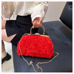 Detail of red floral evening clutch with 3D roses and gold metal round handle