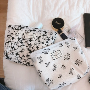 Detailed view of black and white floral bubble cotton cosmetic bags with fabric label