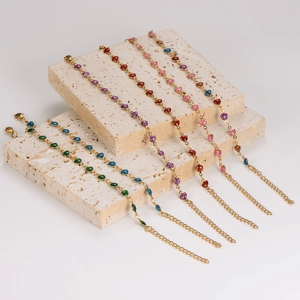 Colorful heart-shaped rhinestone bracelets in gold alloy displayed on beige stone