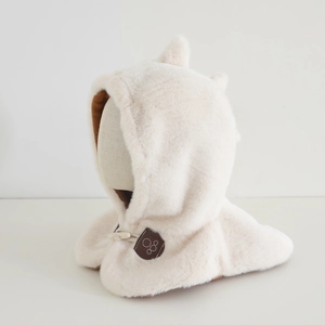 Dettaglio del cappuccio a dinosauro in peluche con orecchie e chiusura a bottone in pelle