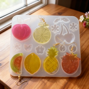 Detailed view of DIY fruit resin earring molds and finished sparkling jewelry pieces