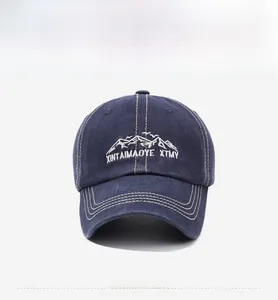 Macro view of white mountain embroidery on washed navy denim cotton baseball cap