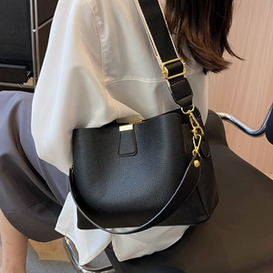 Chic black pebbled leather bucket bag featuring a stylish wide patterned shoulder strap