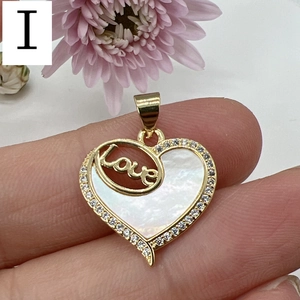Detailed view of mother of pearl heart pendant with gold Love lettering and zircons