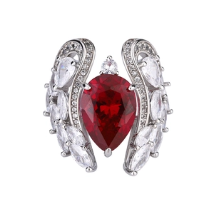 Elegant silver ring with a large pear-shaped red gemstone and sparkling wing design