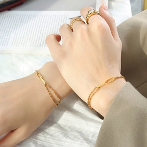 Gold titanium steel square link bracelets and rings set shown on woman's hand