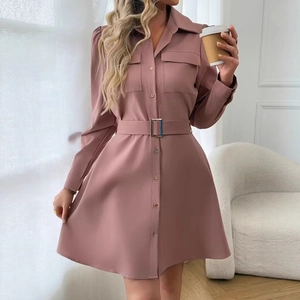Detail view of pink shirt dress featuring front pockets and waist belt with metal buckle
