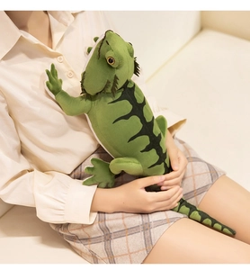 Detailed plush green iguana toy with realistic crest held by person for size comparison
