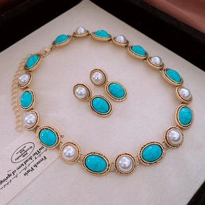 Macro view of vintage gold necklace and earrings set with turquoise and pearls